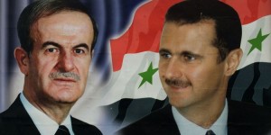 Syrian workers places a banner greeting Pope John Paul ll under a huge poster of Syrian President Bashar al-Assad and his late father Hafez al-Assad at the Abbasiin Stadium in Damascus May 4, 2001. The Pontiff arrives in the Syrian capital on Saturday for a historic visit.JS/GB